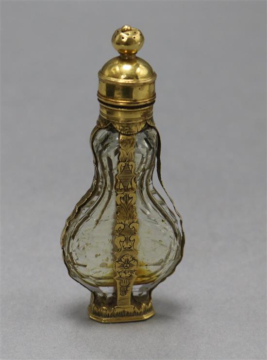 A late 18th century French yellow metal mounted glass scent bottle, with pierced removable finial.